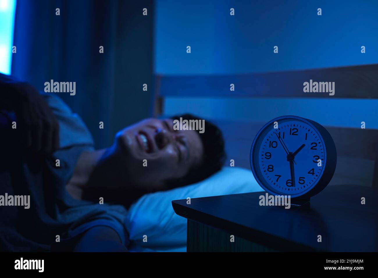 Man unable to sleep due to tropical night Stock Photo - Alamy