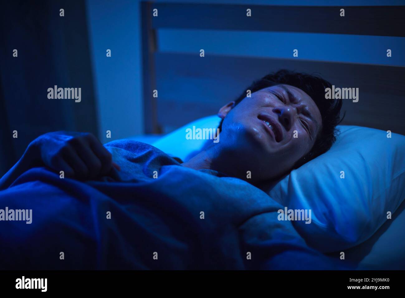 Man unable to sleep due to tropical night Stock Photo - Alamy