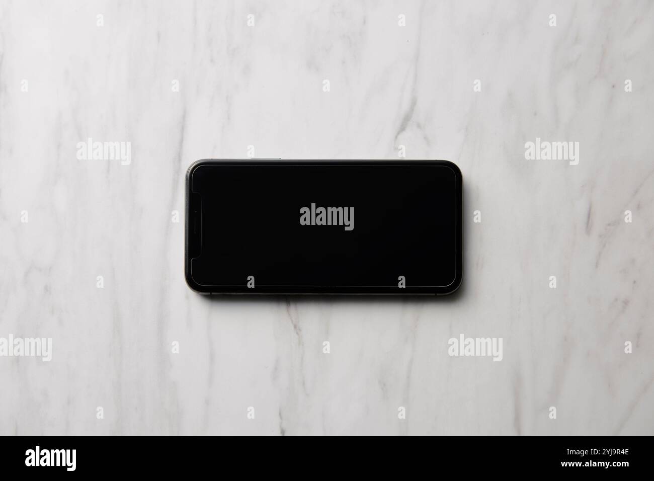 Smartphone placed on marble baking sheet Stock Photo