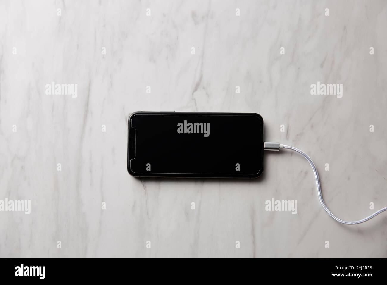 Smartphone placed on marble baking sheet Stock Photo