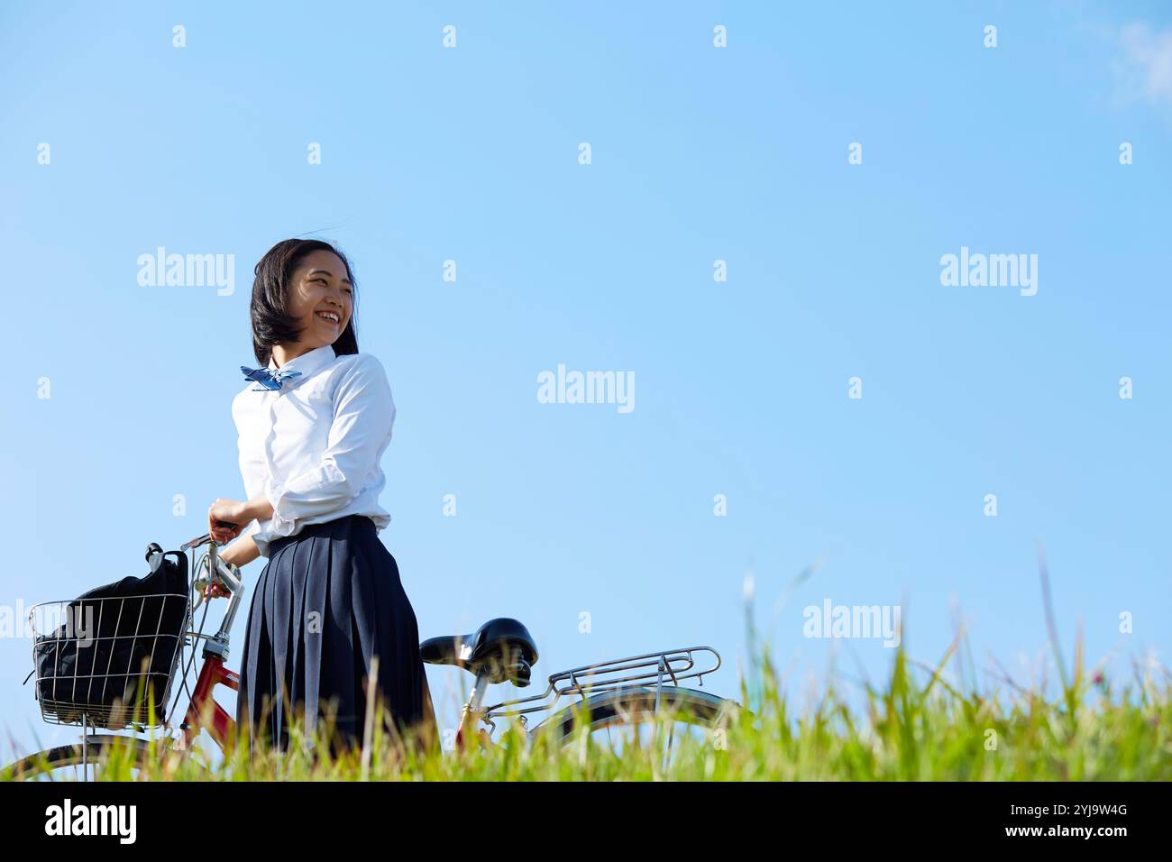 High school girl pushing bicycle and walking Stock Photo