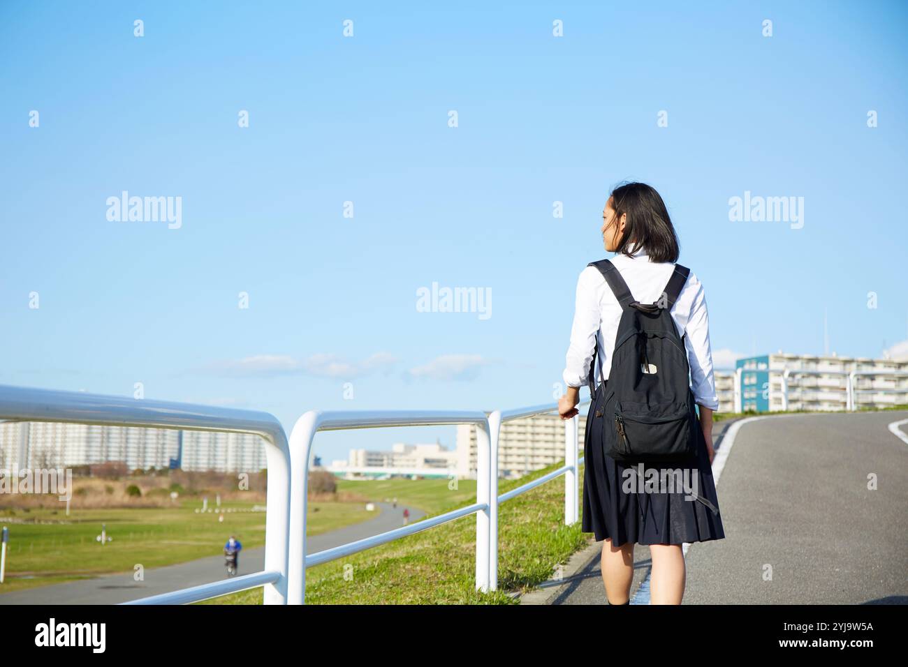 Back view of high school girls walking on the road Stock Photo