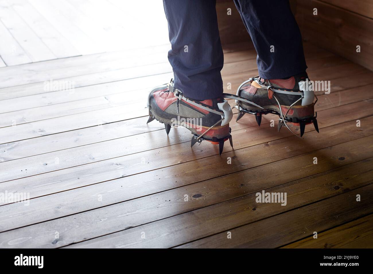 People wearing trekking shoes fitted with crampons inside a mountain hut Stock Photo
