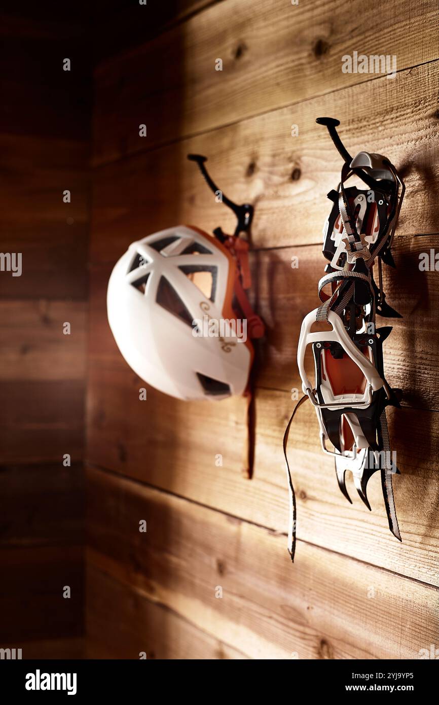 Crampons and helmet on hooks inside the hut Stock Photo