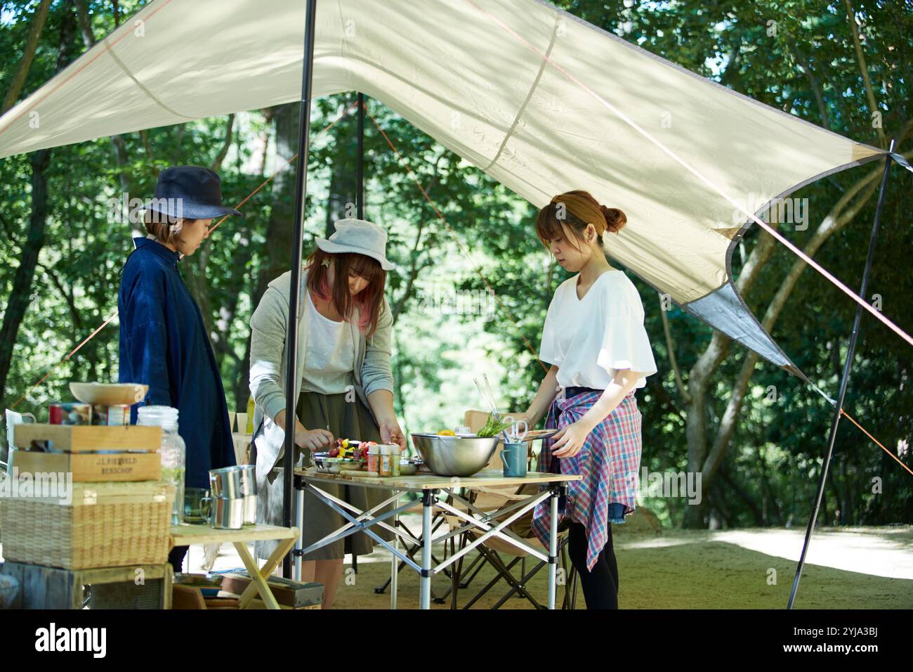 Group of women preparing a barbecue at a campsite Stock Photo