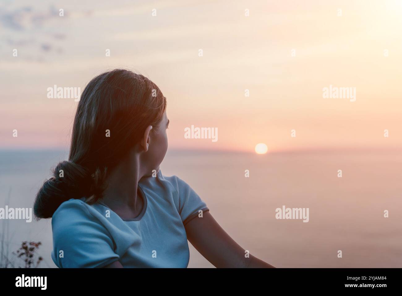 Silhouette of a Girl Watching the Sunset Stock Photo - Alamy