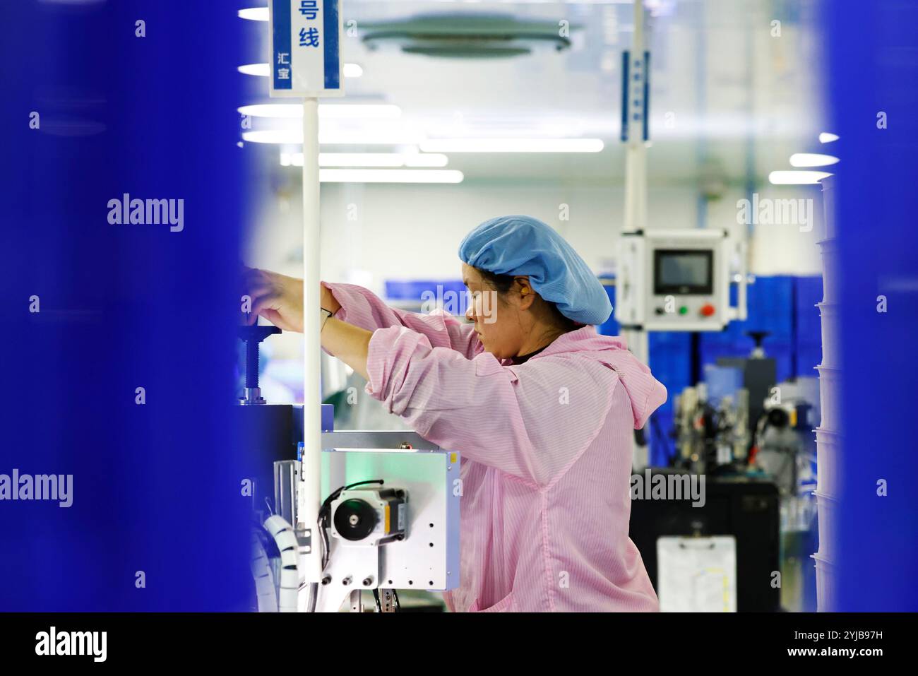 SUQIAN, CHINA - NOVEMBER 13, 2024 - A worker produces new materials for high-end special-shaped anti-counterfeiting bottle caps at a workshop of Sihon Stock Photo