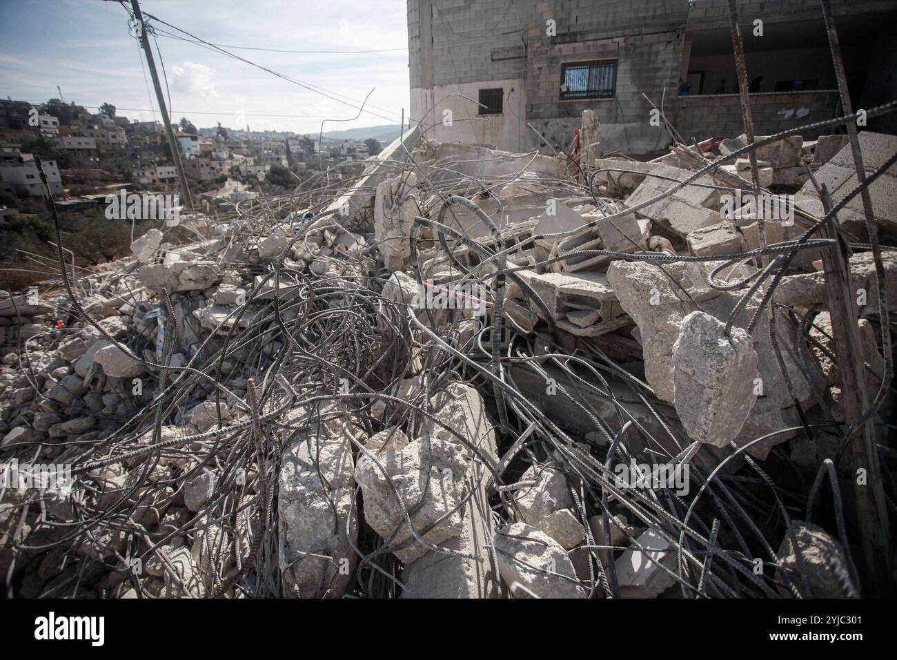 Palestinians inspect the destruction of a house after Israeli ...