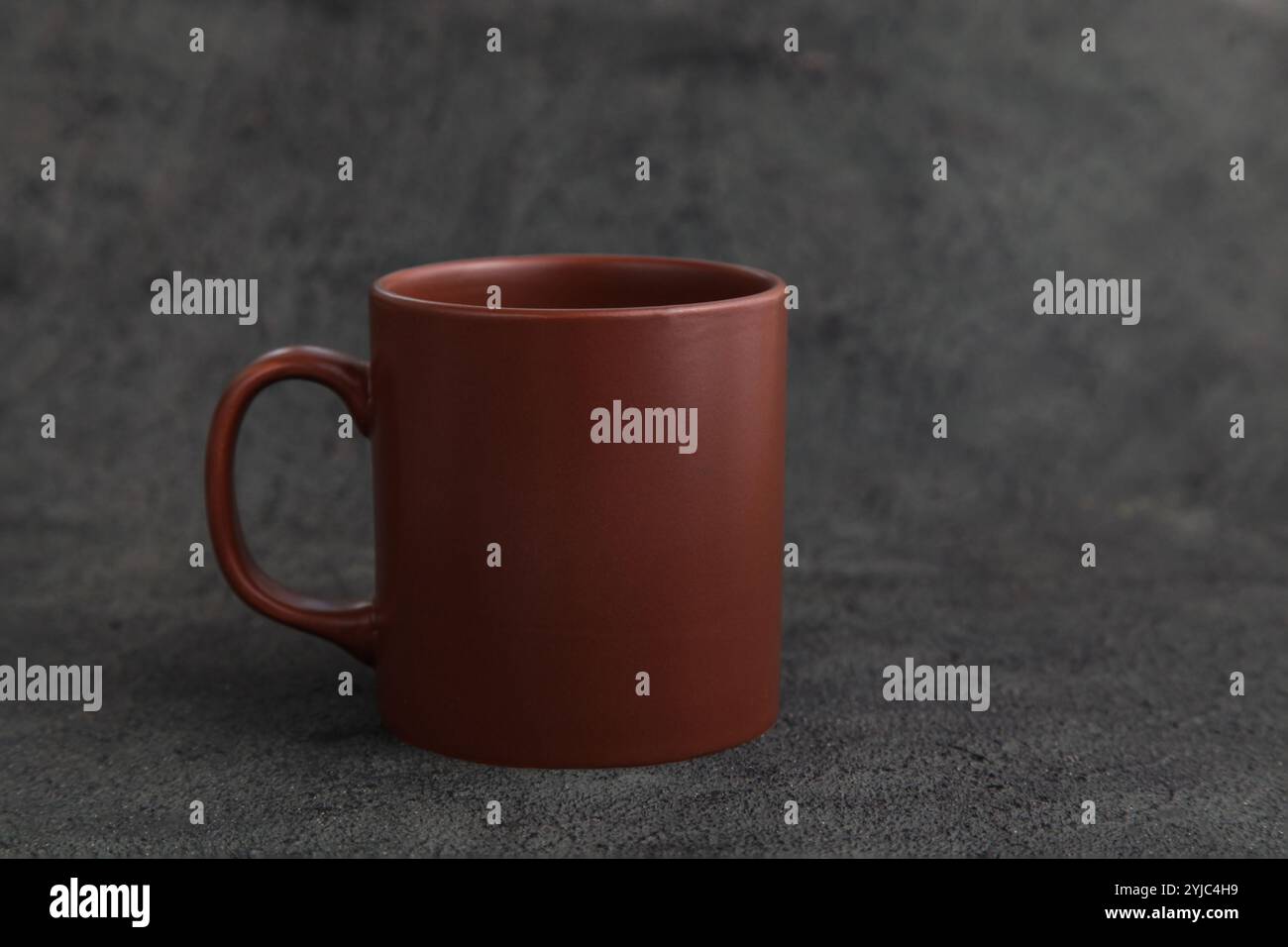 Empty Brown Ceramic Mug. Rustic Cup on Dark Grey background. Copy space. Rustic Dishes Stock Photo