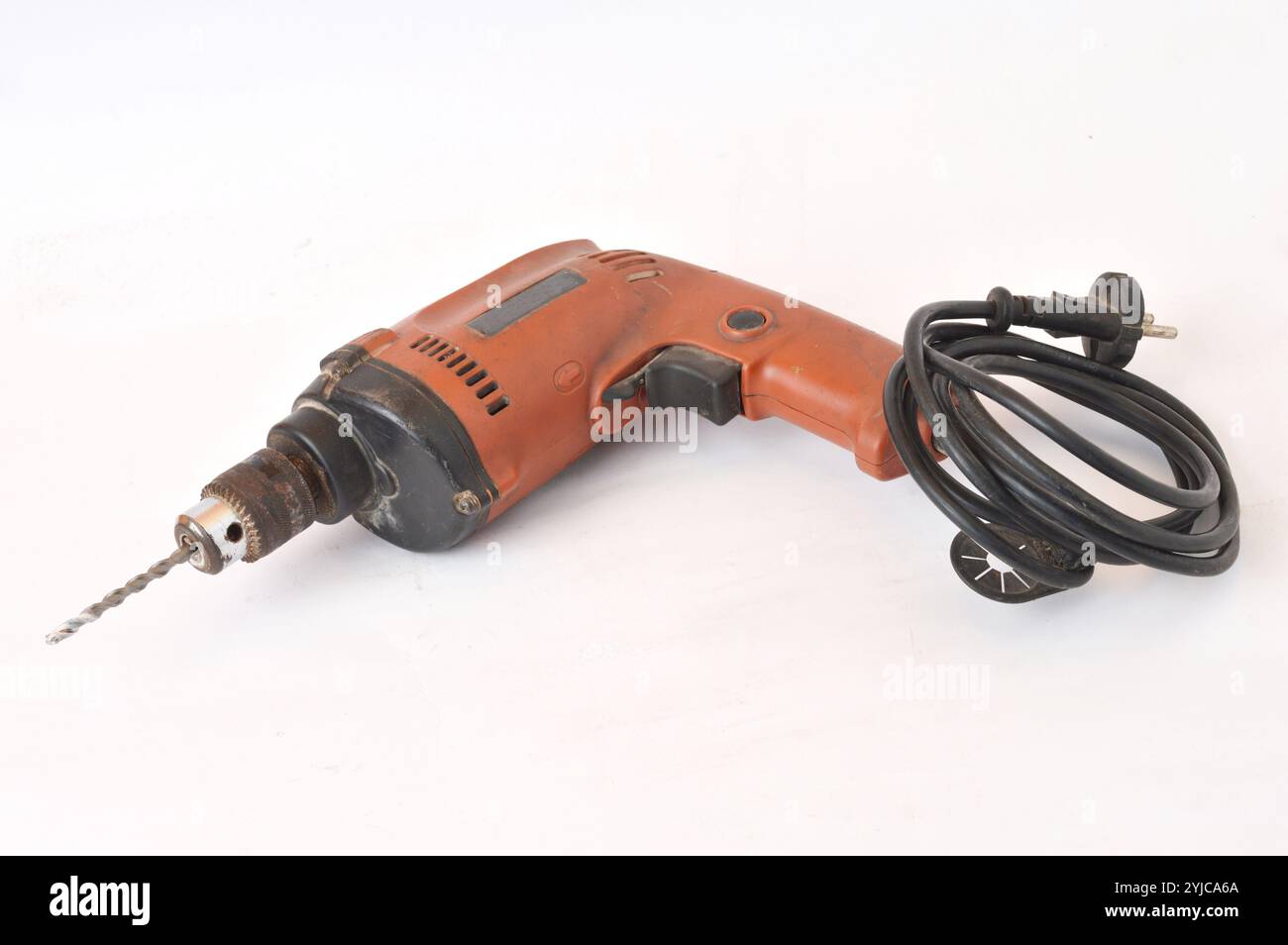 old used orange hand drilling machine on white background Stock Photo