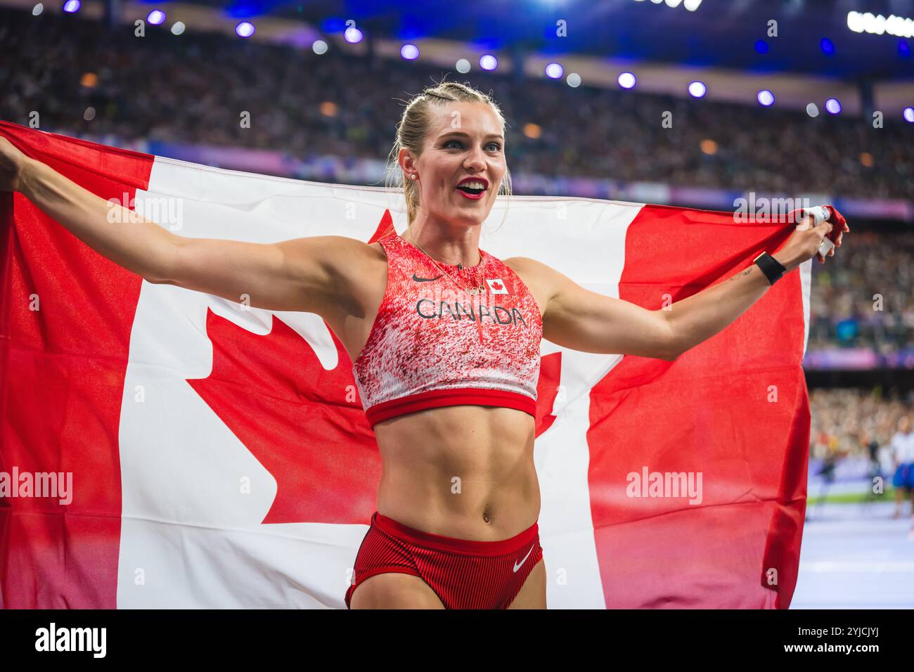 Alysha Newman celebrating her medal with her country's flag at the
