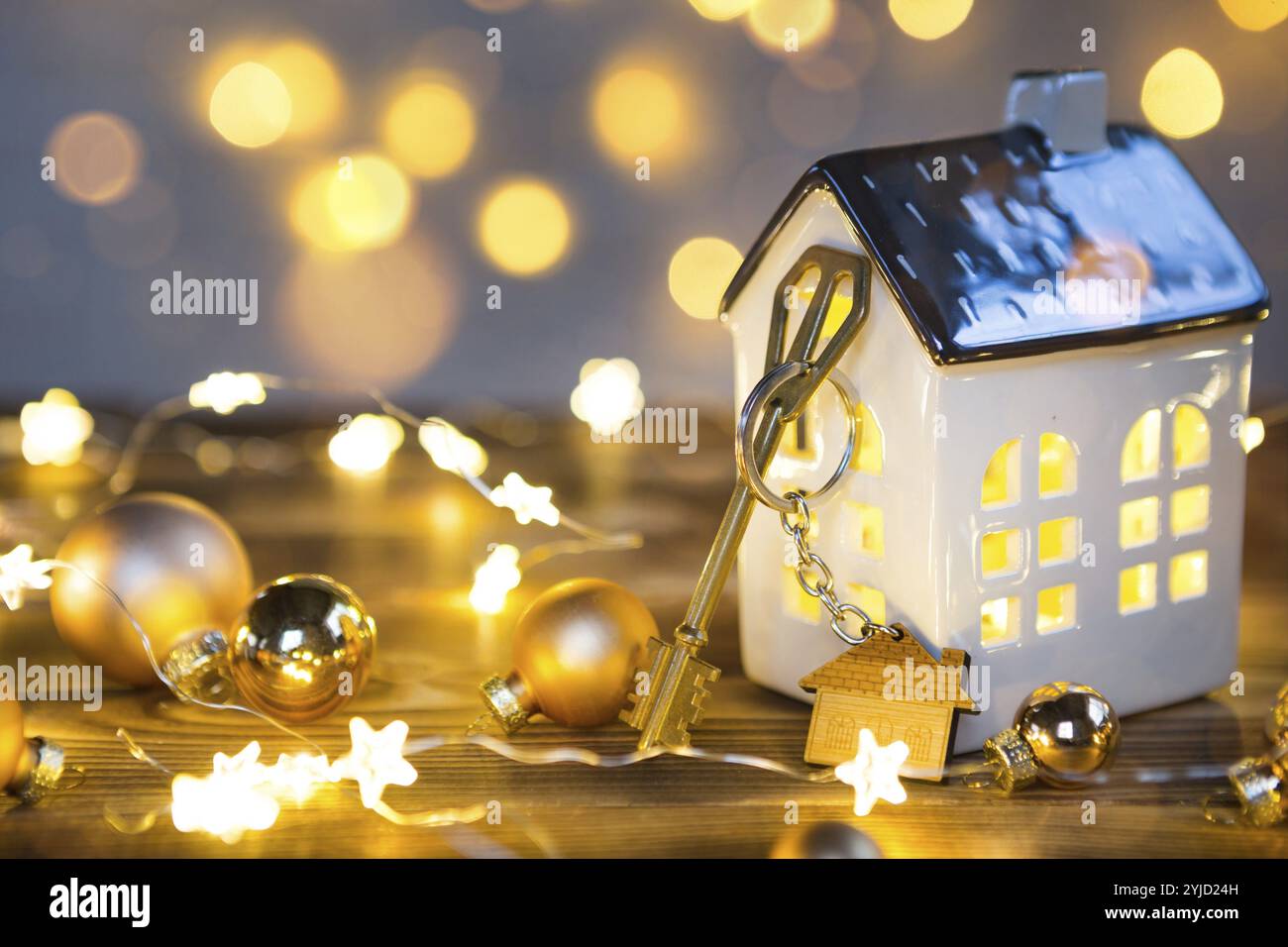 Key to the house with a keychain on a lamp with a Christmas decor. A gift for New Year, Christmas. Building, design, project, moving to new house, mor Stock Photo