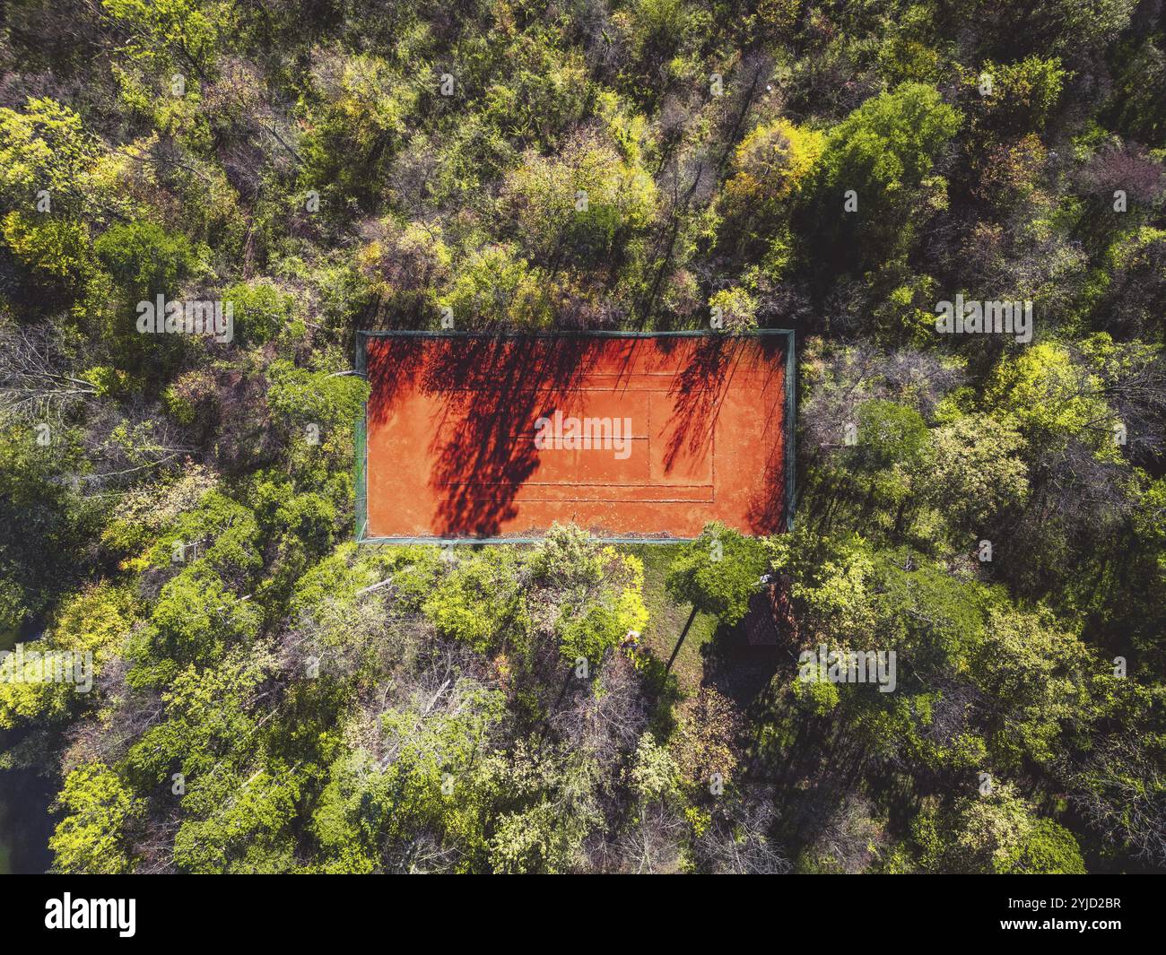 Tennis court in the forest from aerial top view. Stock Photo