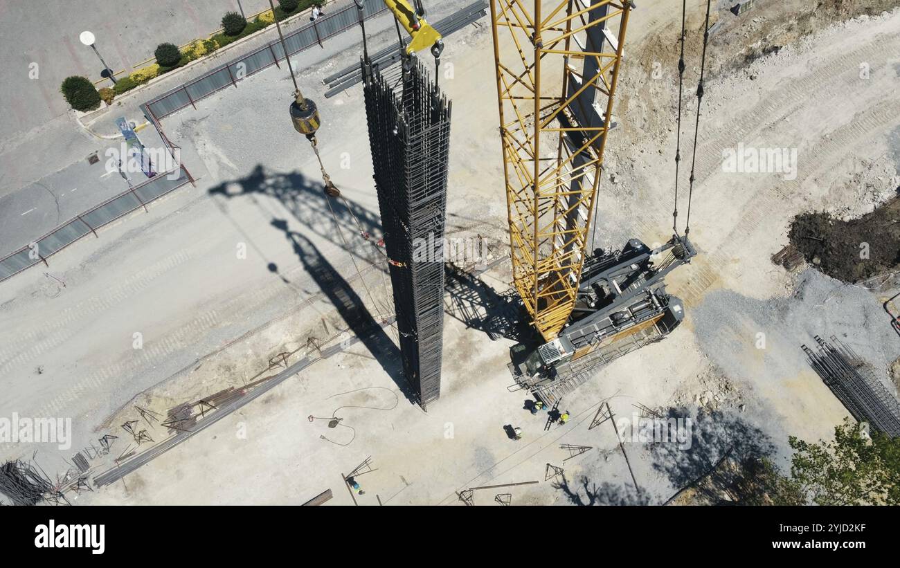 Aerial view of a construction site with a crane and workers handling ...