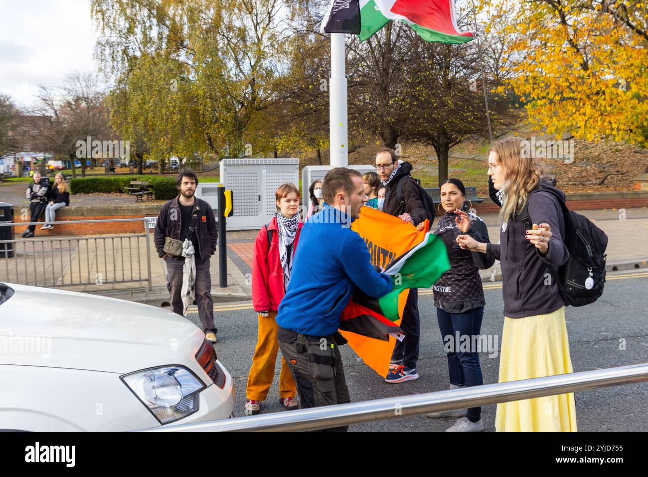 Leeds, UK. 14 NOV, 2024. Person rips Palestine flag out of activists hand as protestors from action group Youth Demand stepped out in the road for the 3rd time this week, in a nationally co-ordinated action seeing small swarms block traffic for up-to 15 minutes aiming to highlight the ongoing situation in Palestine. During todays action a number of irate drivers physically moved and grabbed at the protestors, the activists did not fight back but did not leave the road, police were called but did not attend,. Credit Milo Chandler/Alamy Live News Stock Photo