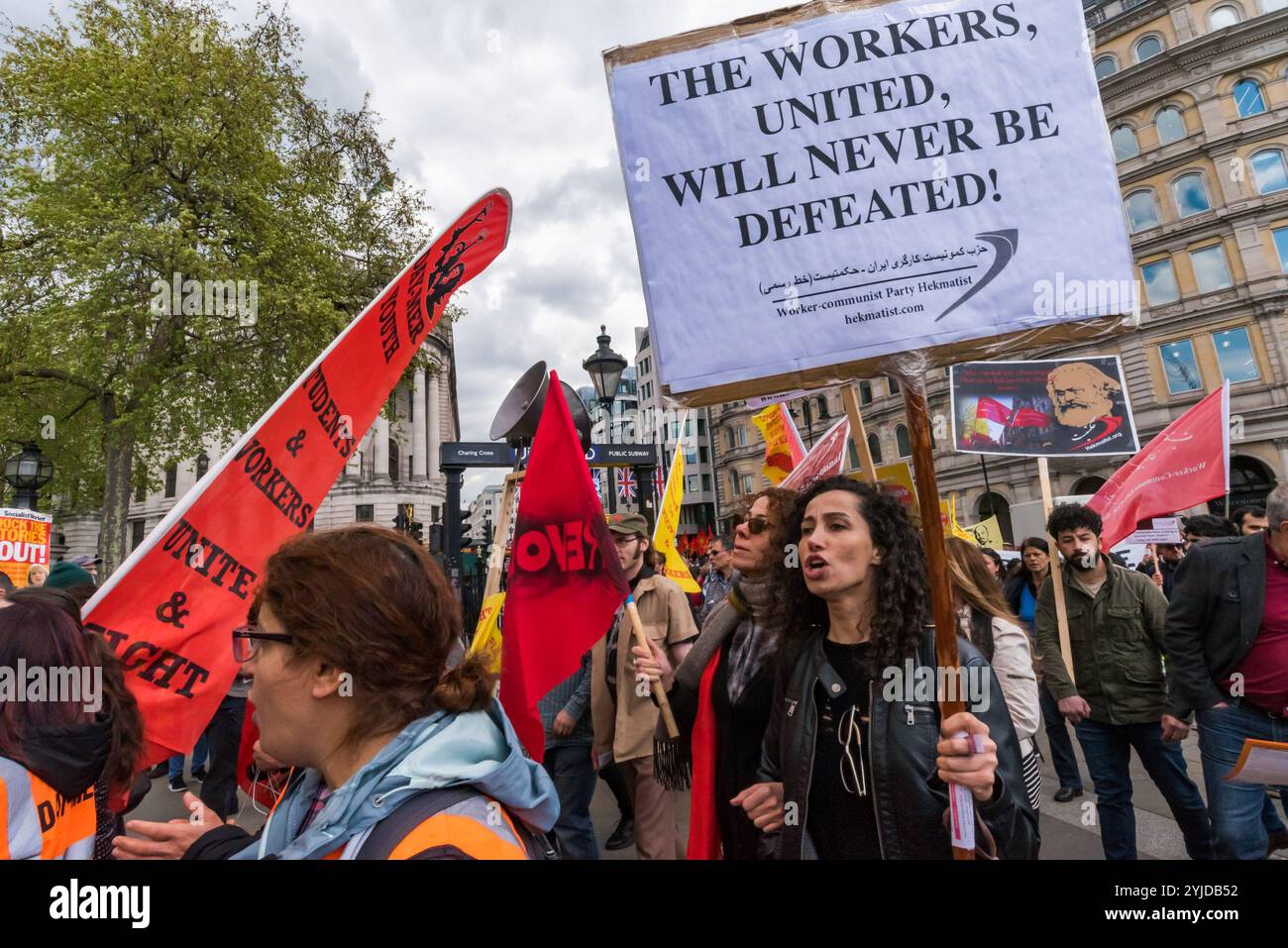 A rally in Trafalgar Square including many  from London's international and migrant communities celebrates  International Workers Day. Some held flags and banners on the plinth of  Nelson's Column  while others listened to the speeches by a number of  trade unionists and activists and included a short silence in memory of  Mehmet Aksoy who was killed in Syria whilst filming with Kurdish  fighters and had spoken for the Kurds at previous events. At the end of  the rally there was a speech by Brixton Ritzy trade unionist Kelly  Rogers victimised by Picturehouse and the various precarious workers Stock Photo