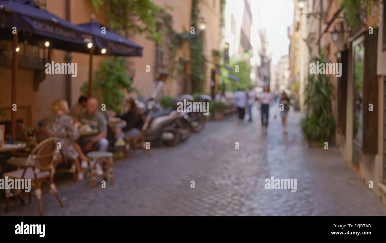 Blurred people walking on a cobblestone street in rome with bokeh ...