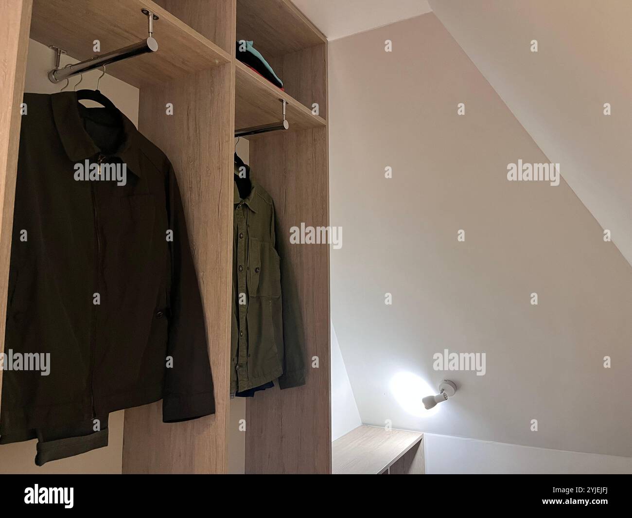 Basic student accommodation interior and jackets hanging in open wardrobe Stock Photo
