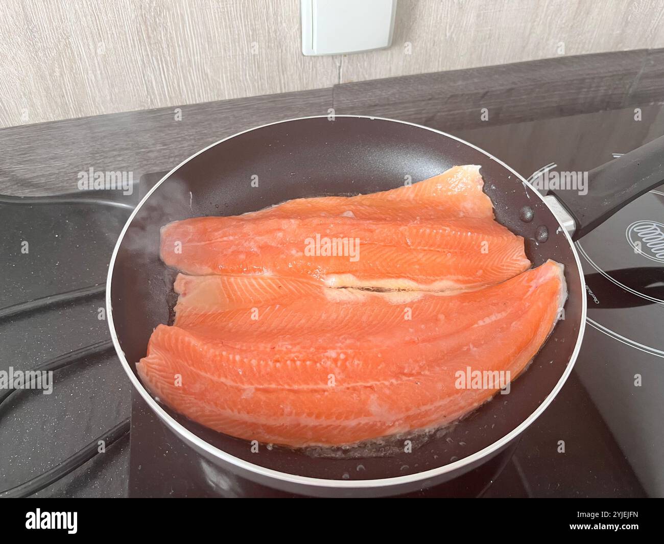 Sea trout fillet basic home cooking in frying pan - Smartphone Captured Stock Image