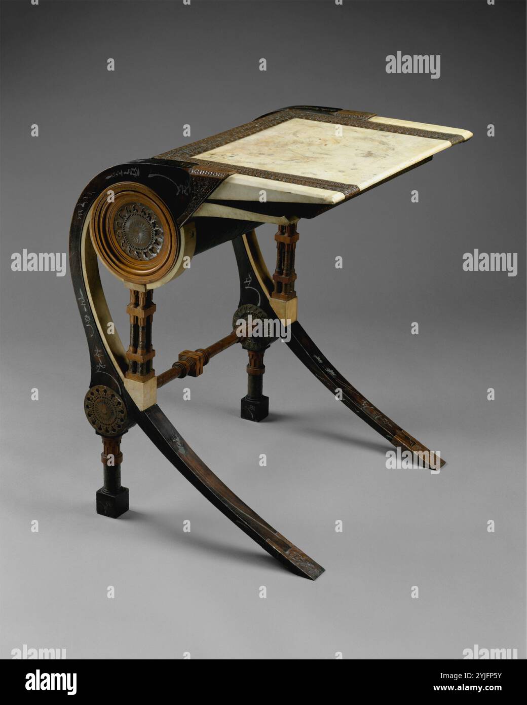 Desk. Artist: Carlo Bugatti (Italian, Milan 1855-1940 Molsheim). Dimensions: H. 29-1/2, W. 23-2/3, D. 22-1/2 in. (74.9 x 60.1 x 57.2 cm). Date: ca. 1902. Strikingly original, Carlo Bugatti's furniture combines the picturesque asymmetry of Art Nouveau with the exoticism of Moorish and Japanese influences. Yet, there is nothing derivative in Bugatti's work; rather, it is pure fantasy, drawing inspiration from the Orientalist art movement of the late nineteenth century, a fact underscored by the name of his business in Milan: C. Bugatti & C., Fabbrica Mobili Artistici Fantasia. The writing surfac Stock Photo