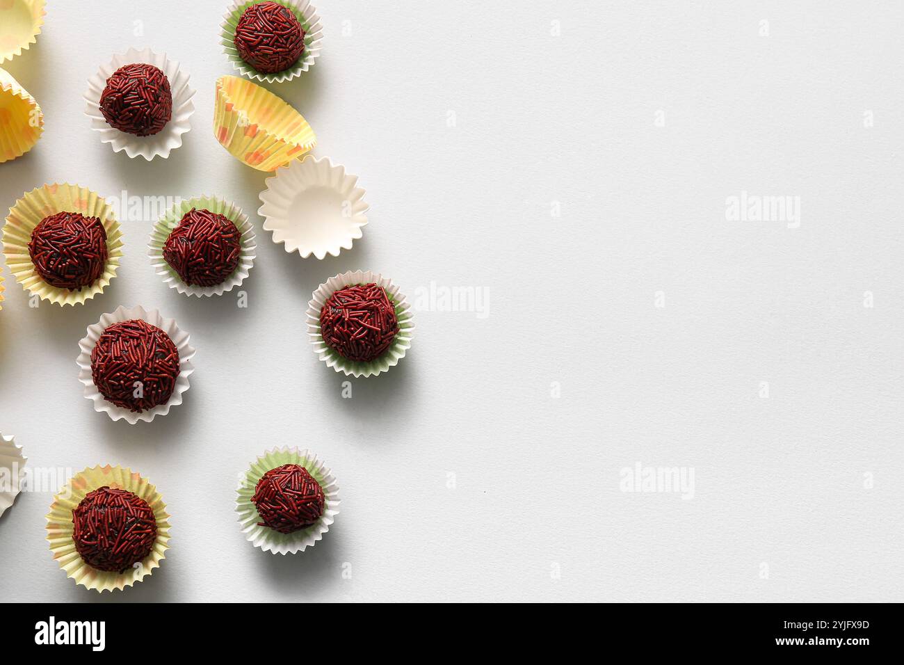 Delicious chocolate truffles in colorful paper cups on white background ...
