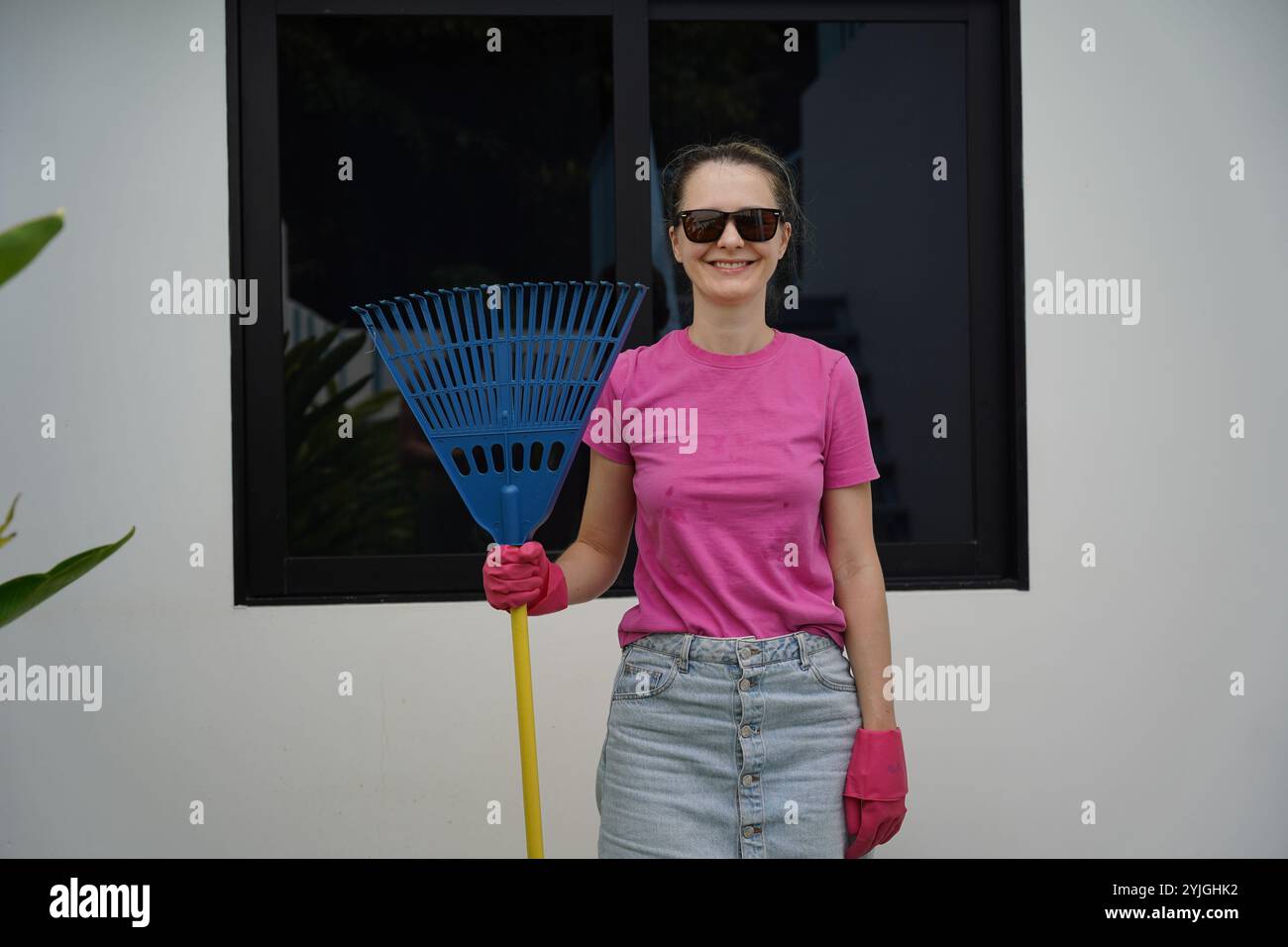 Woman Racking Lawn A woman raking the lawn at the backyard of her house Stock Photo - Alamy