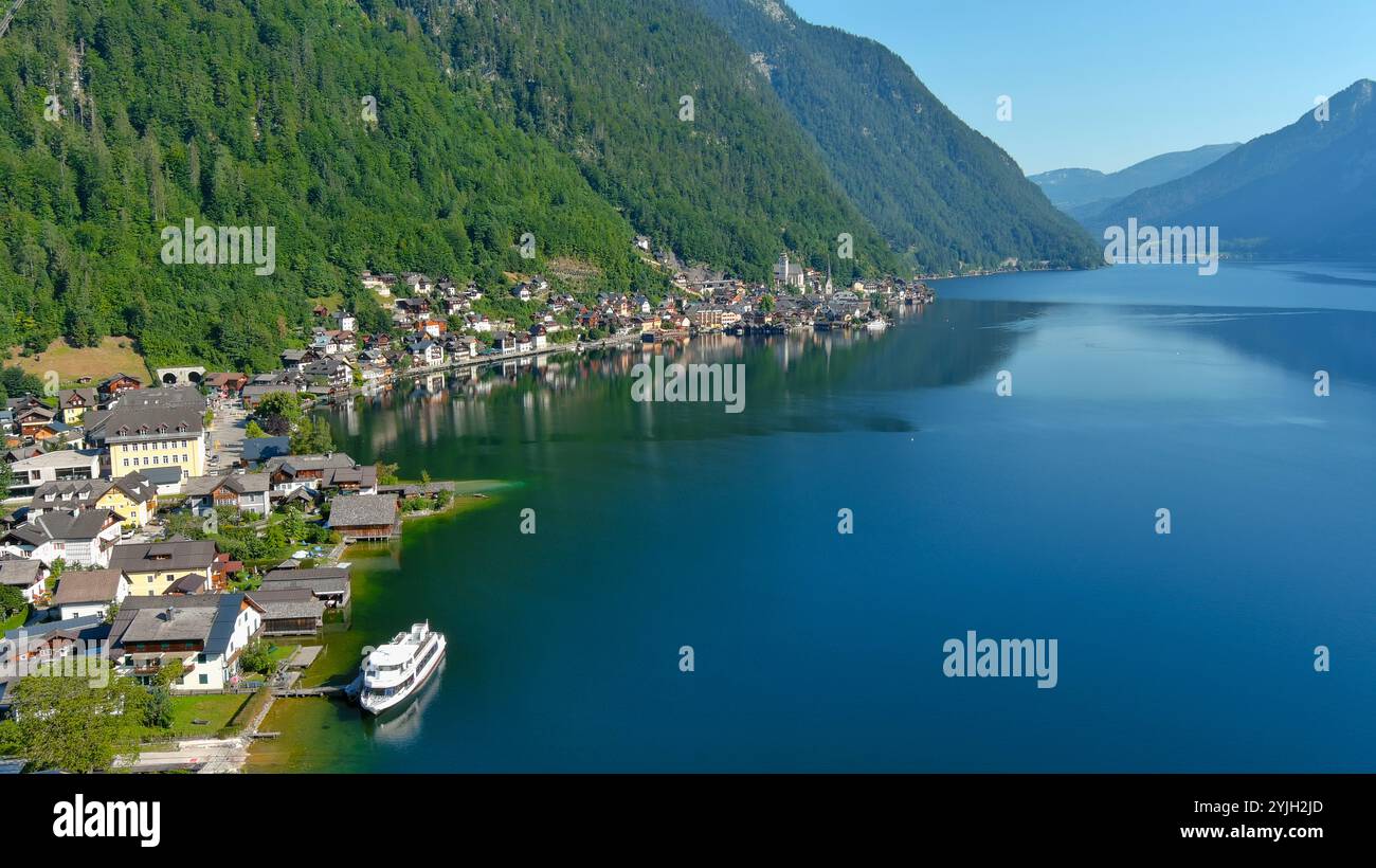 Tranquil Hallstatt lake scene with colorful village houses nestled by the water and surrounded by green mountains Stock Photo