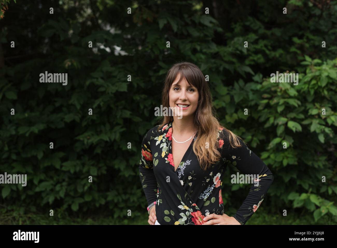 Fashion portrait of healthy, happy young woman with leafy backdrop Stock Photo