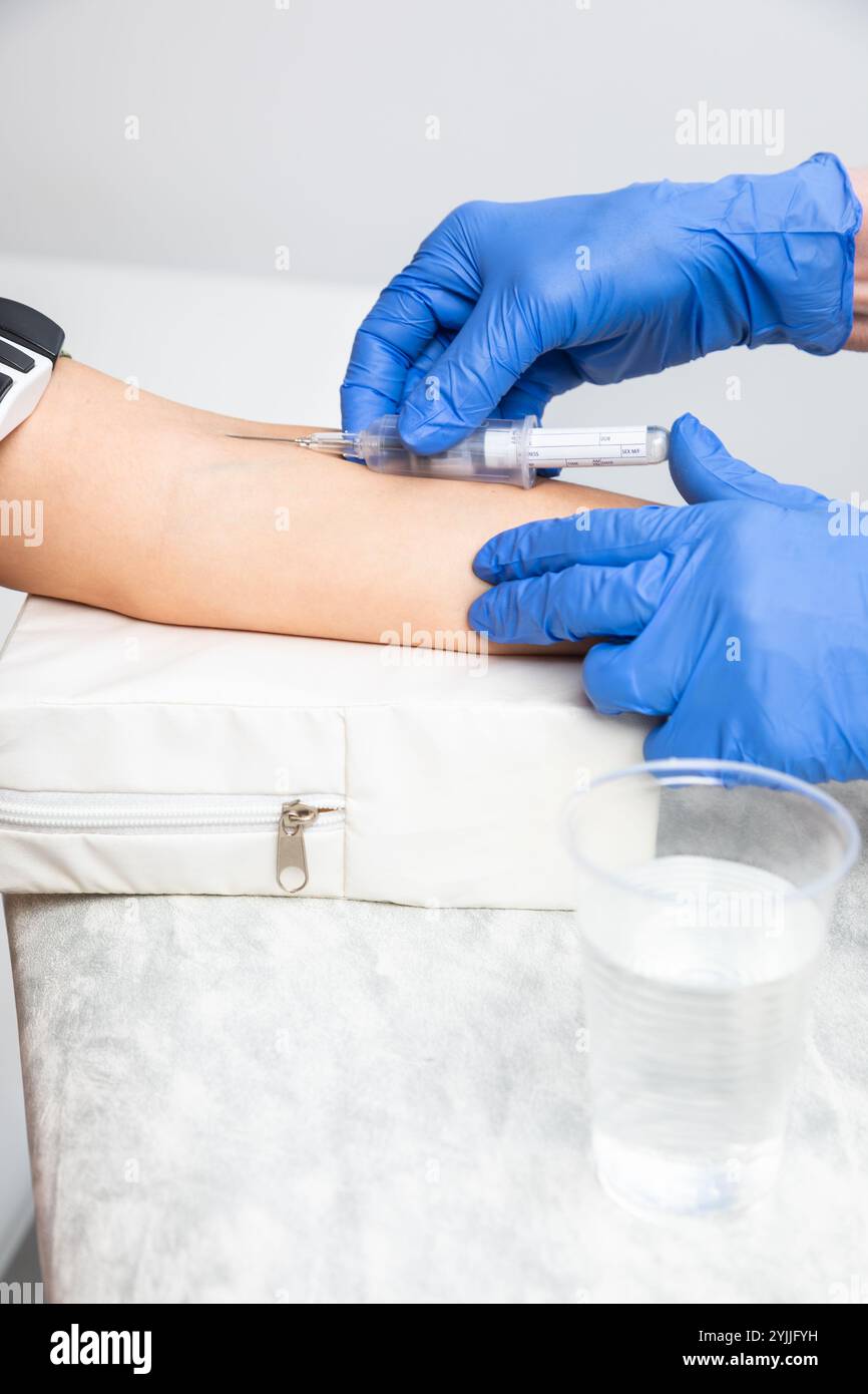 Close-up shot of healthcare worker wearing gloves takes a blood sample ...