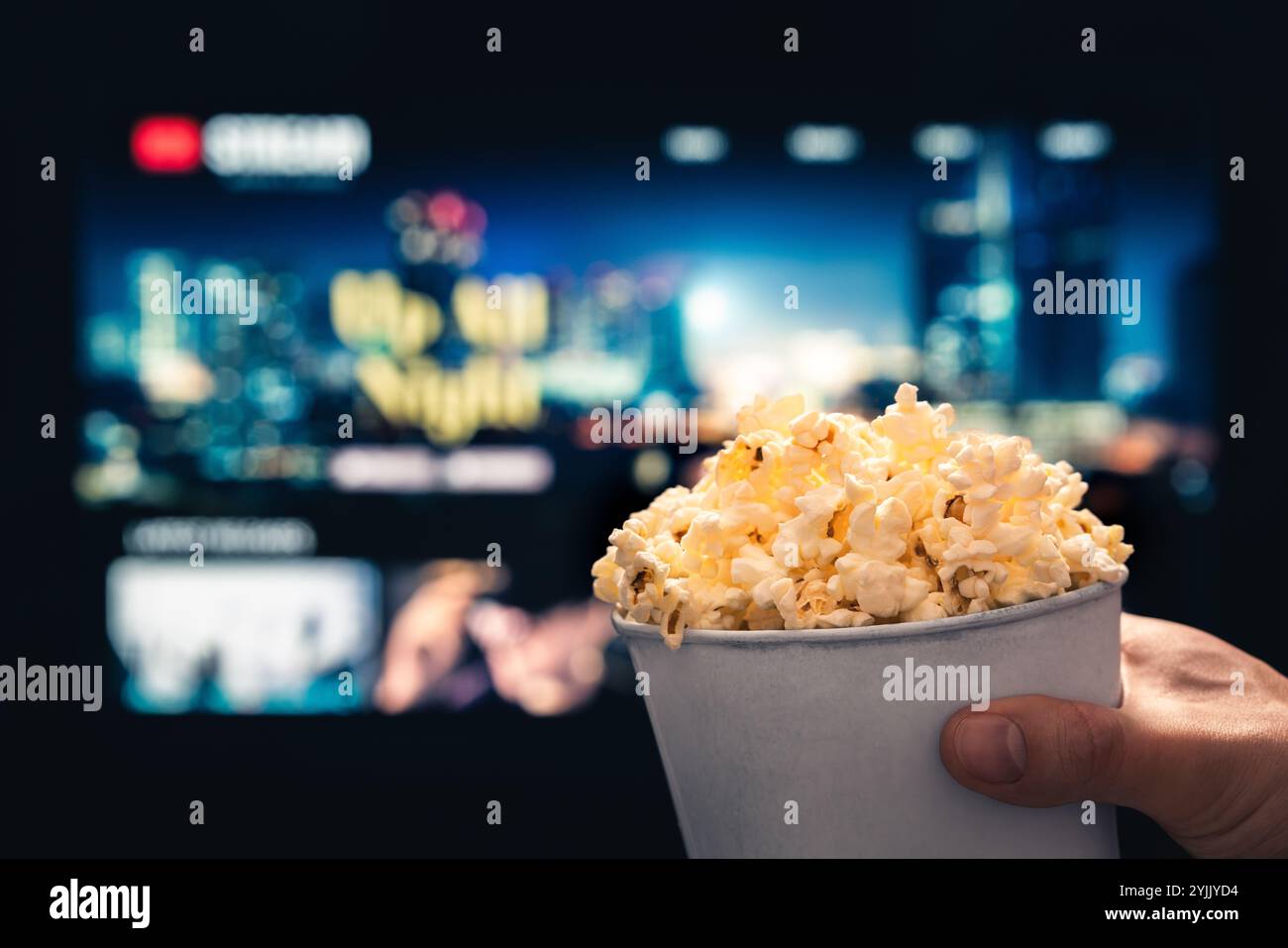 Tv streaming and popcorn. Watching movie from stream service in television. Film night and snack. Pop corn, couch and vod series. Home cinema. Stock Photo
