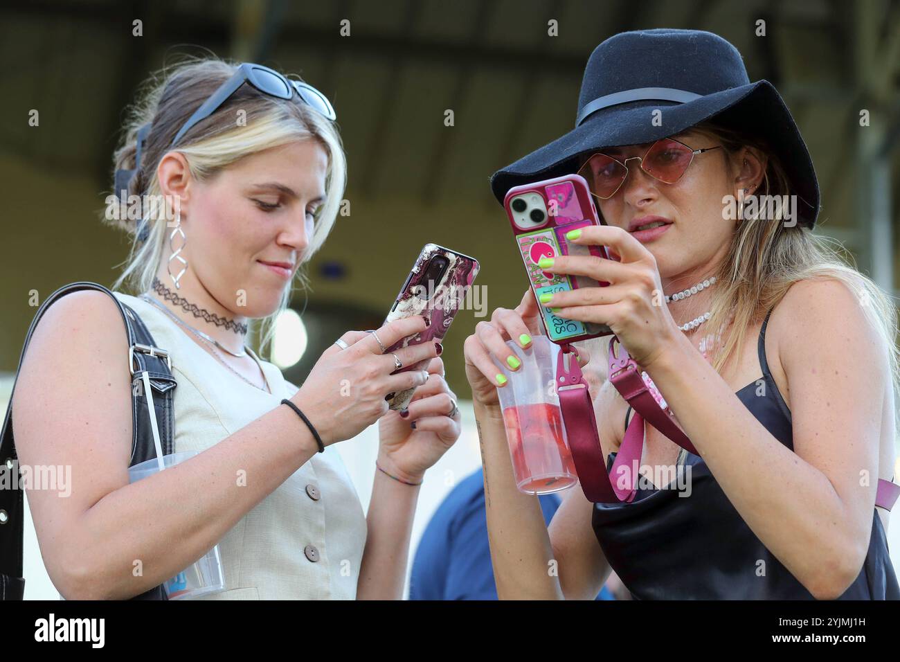 11.07.2024, Leipzig, Sachsen, GER - Jugendliche schauen auf ihre Smartphones. 15-20 Jahre, Alltag, aussen, Aussenaufnahme, chatten, deutsch, Deutschland, Elektronik, Empfang, Europa, europaeisch, Fashion, Frauen, Freizeit, Freundinnen, Funktelefone, Gesellschaft, Handys, Hut, Informationsaustausch, Jahreszeit, Jugend, jugendlich, Jugendliche, jung, Kaukasierin, kaukasisch, Kommunikation, kommunizieren, Kurzmitteilung, lesen, Maedchen, Menschen, Mitteilung, mobil, Mobilfunk, Mobilfunktelefone, Mobiltelefone, Mode, modisch, Online, Personen, QF, Querformat, Smartphones, SMS, Sommer, Teenager, Te Stock Photo