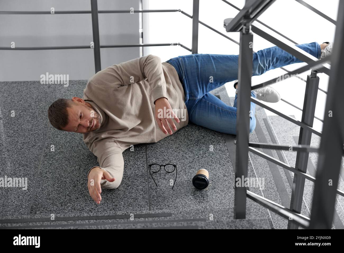 Injured man on stairs in building after fall. Dangerous accident Stock ...