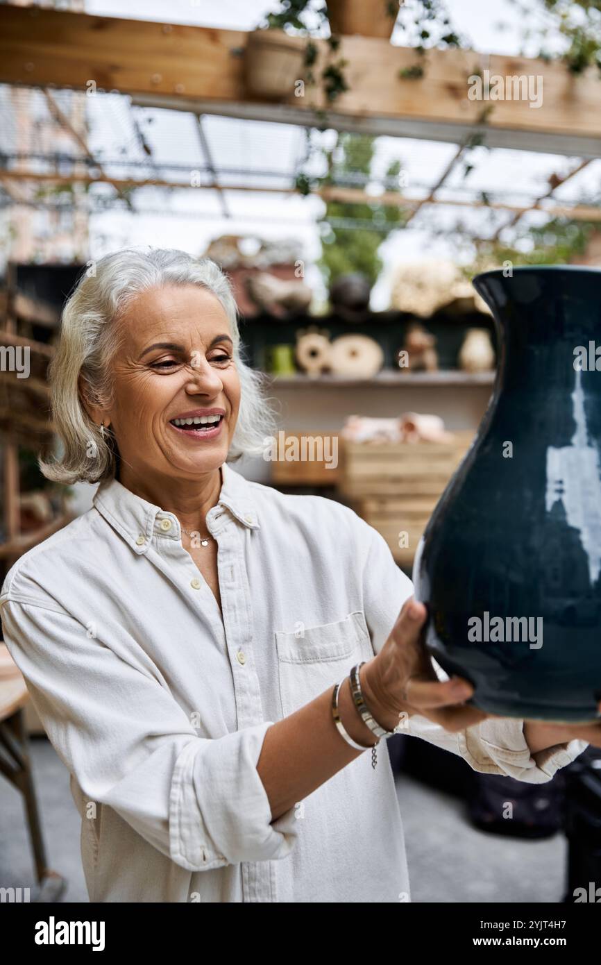 A mature woman smiles brightly while holding a stunning piece of ...