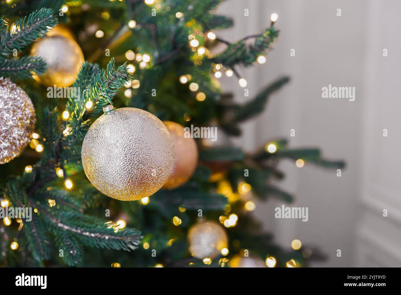 Decorated Christmas tree with golden festive ornaments and shine lights ...