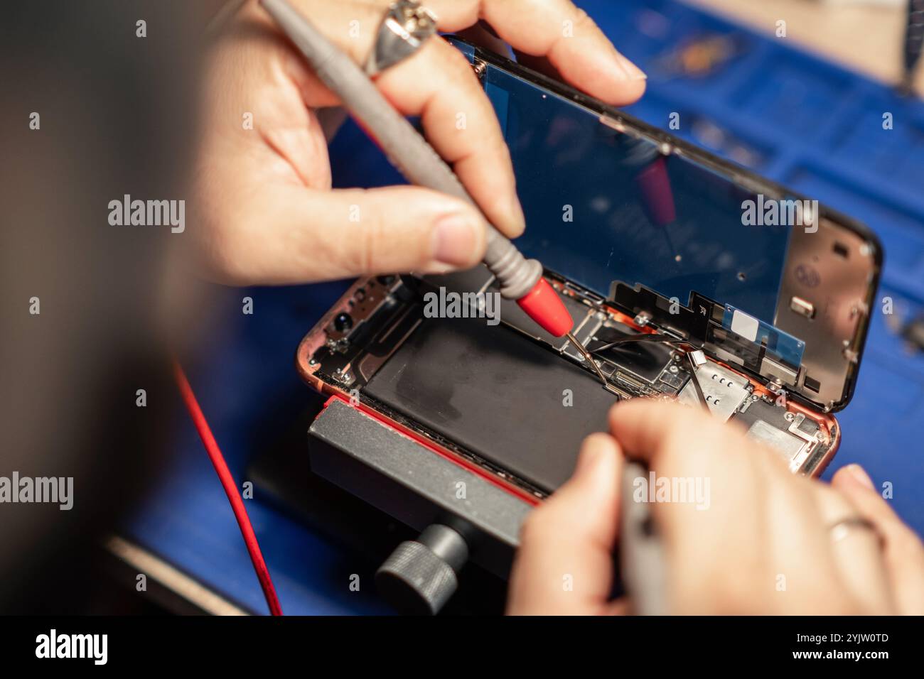 Image showcasing Expert performs smartphone battery repair with precision tools at a ...