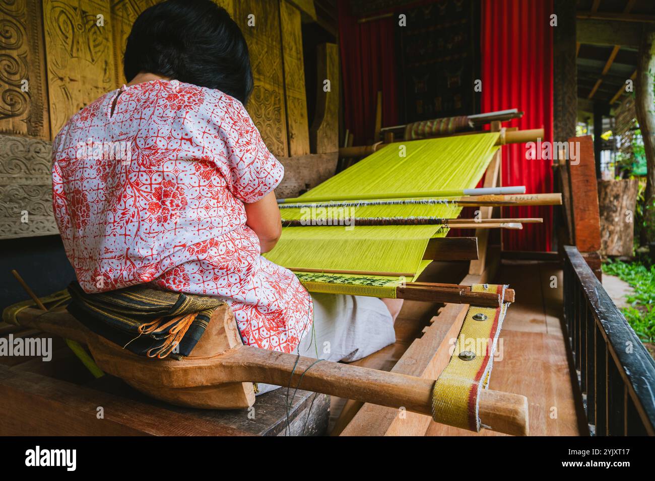 A Torajan woman weaver is weaving on her loom Stock Photo - Alamy