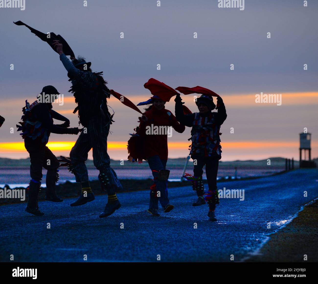 Morris Dancers welcoming in May Day on Holy Island causeway, Northumberland, England, UK Stock Photo