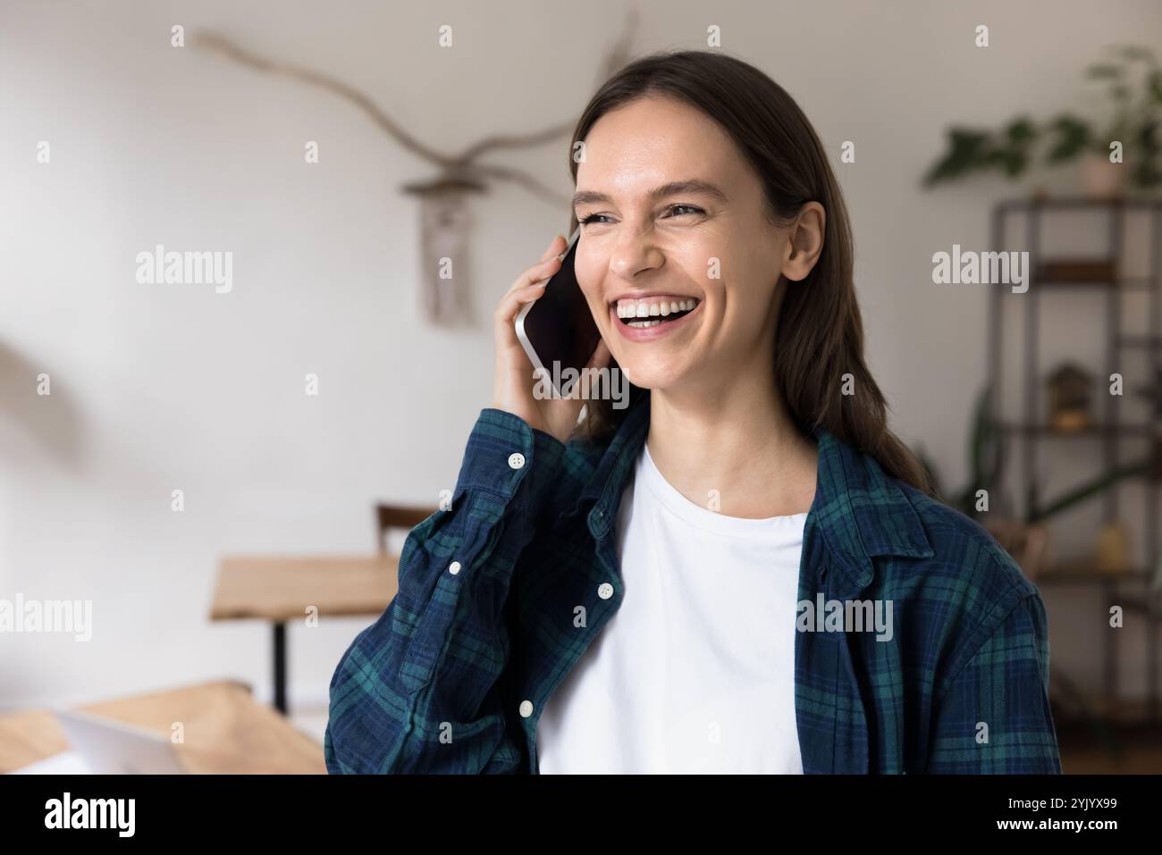 Young woman talking on smartphone at workplace Stock Photo