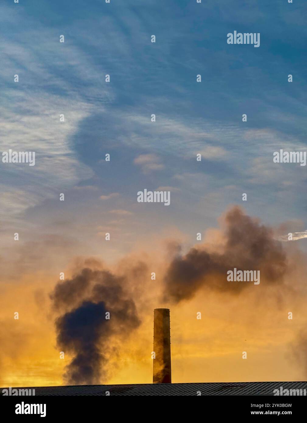 Steam rising from brick chimney stack early on a cold morning, Adlington, Lancashire UK - Smartphone Captured Stock Image