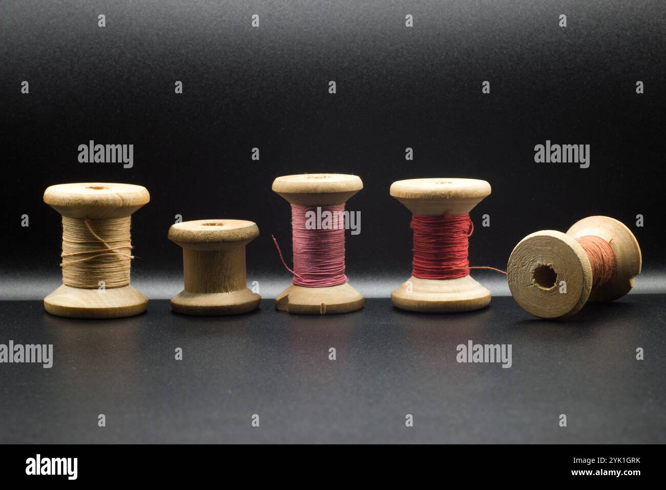 set of colored thread and buttons on a black background Stock Photo - Alamy