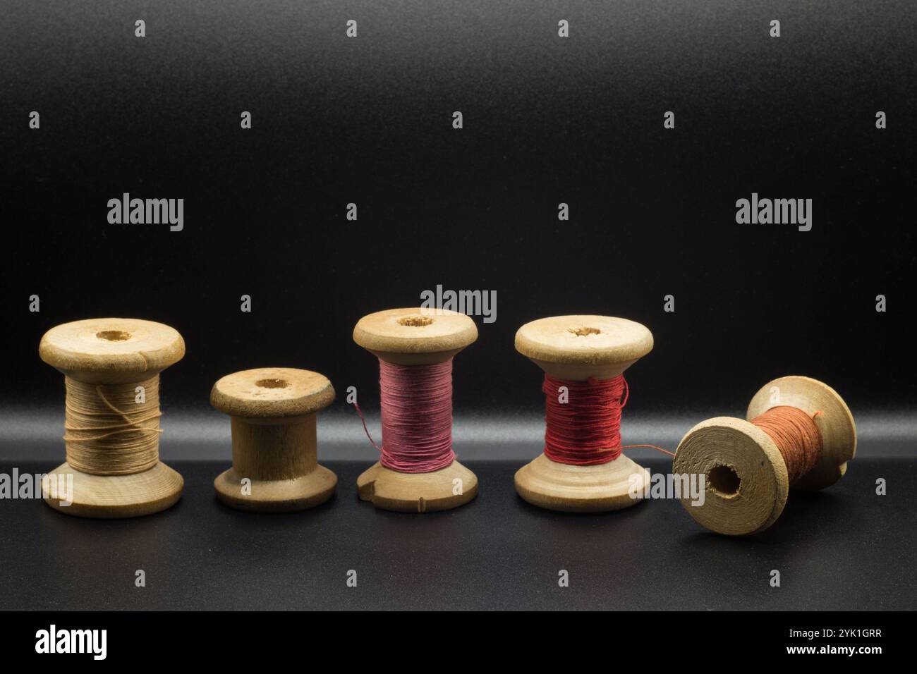 set of colored thread and buttons on a black background Stock Photo - Alamy