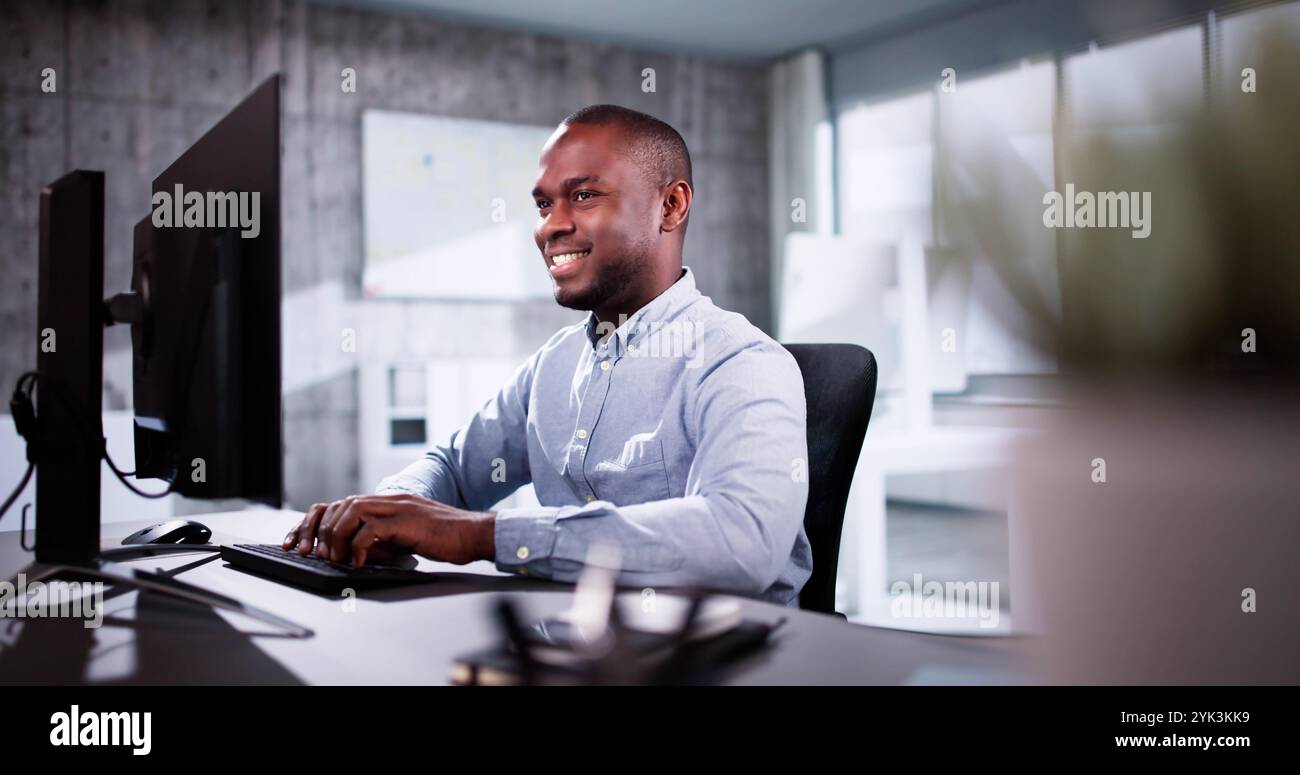 Employee Working On Desktop Computer In Home Office Stock Photo
