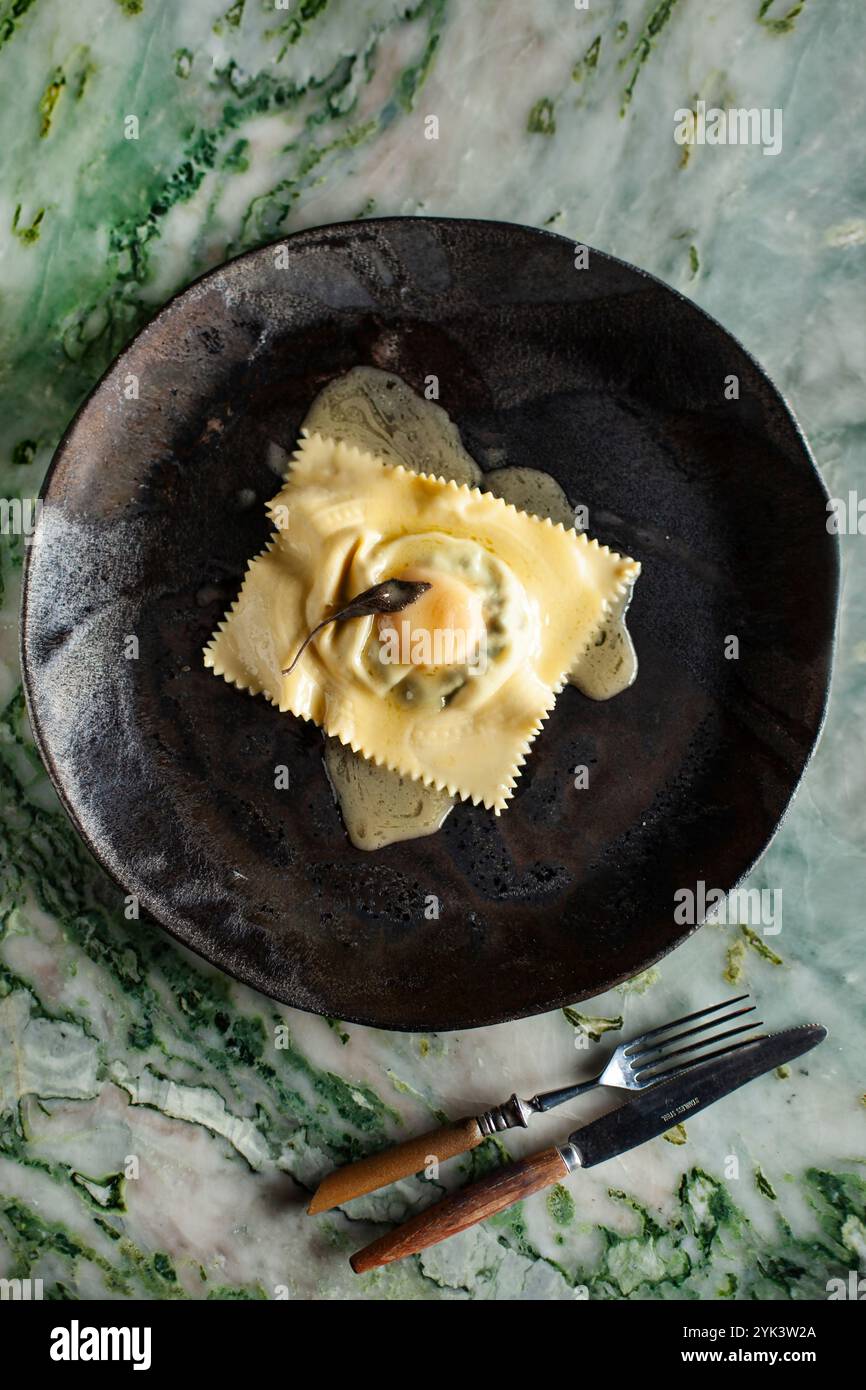 Raviolo filled with egg yolk and melted butter Stock Photo - Alamy