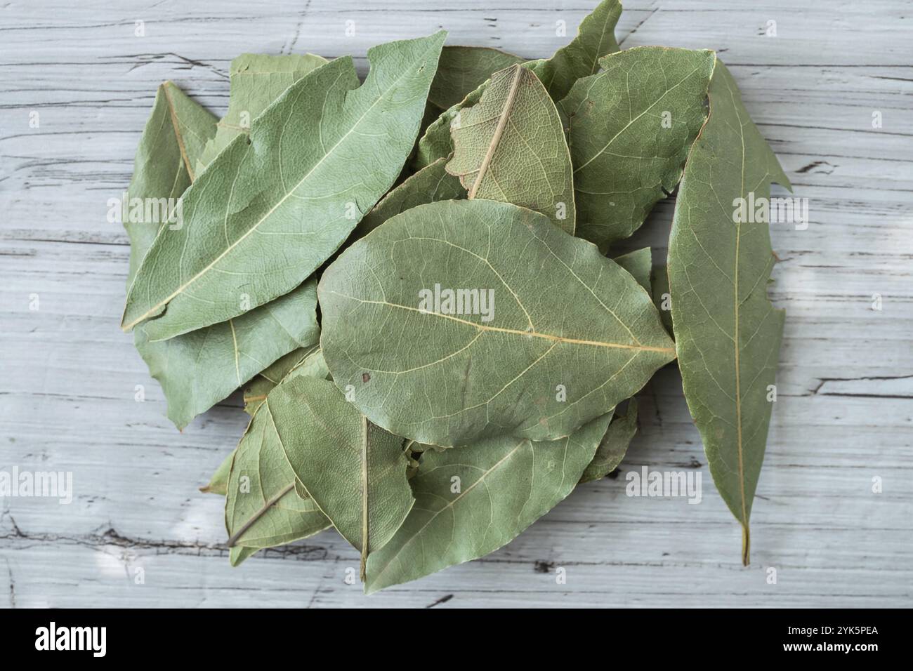 Dried whole bay leaves on cutting board (Laurus nobilis) Stock Photo