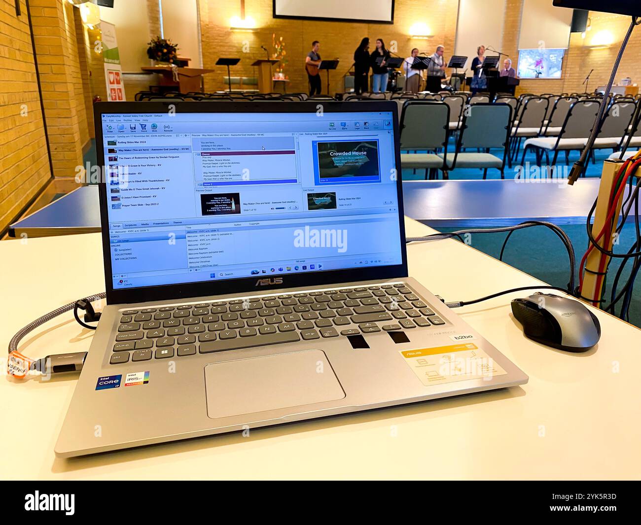 Using a laptop to display song lyrics on a screen at a church praise and worship band practice. - Smartphone Captured Stock Image