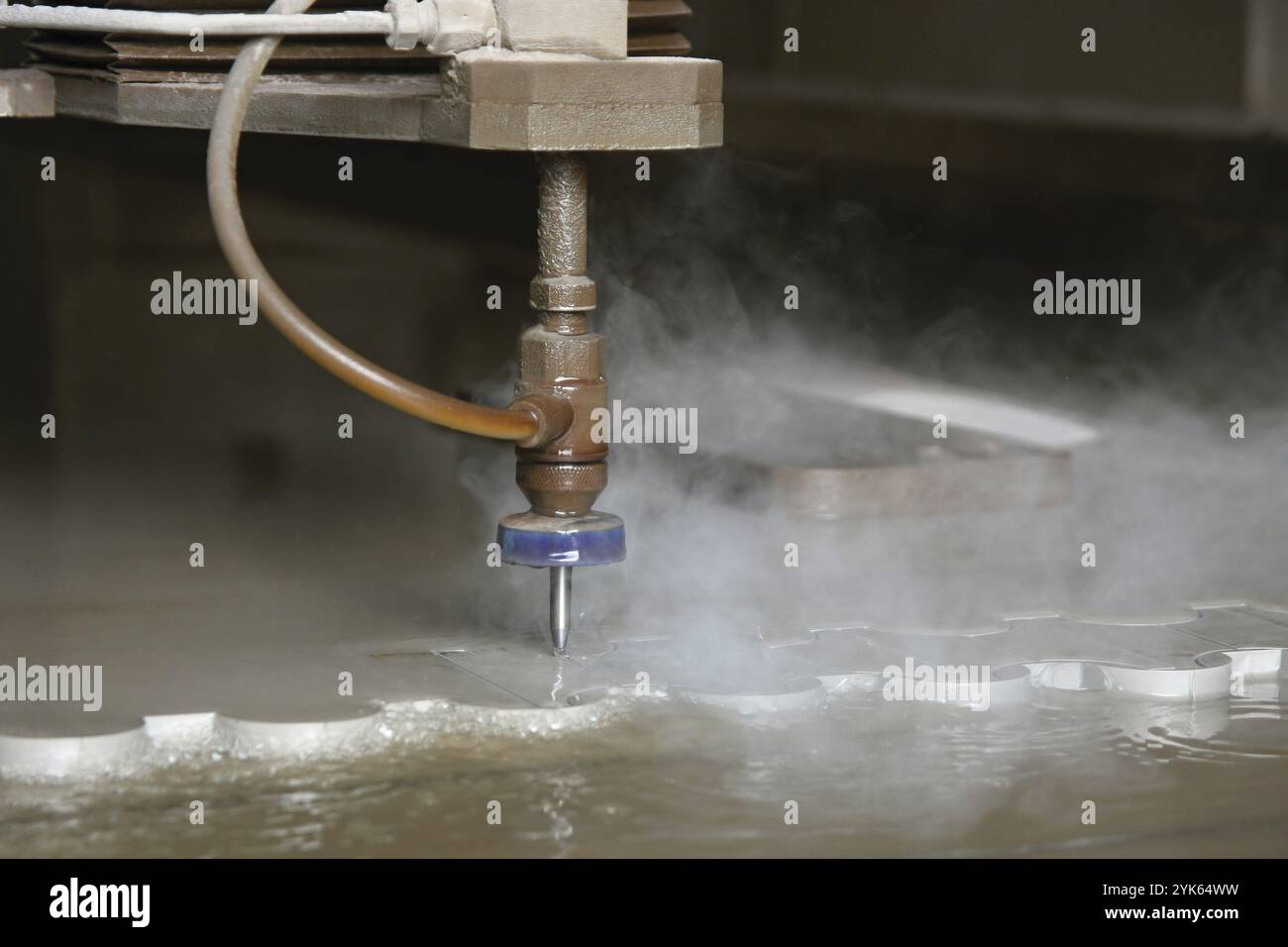 Machine using water pressure to cut through stainless steel materials Stock Photo