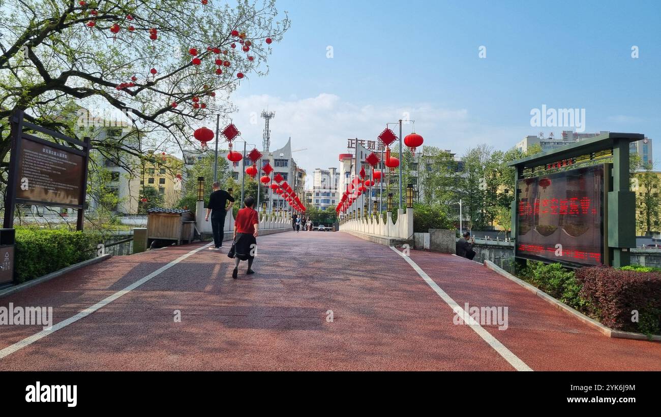 A picturesque bridge adorned with vibrant red lanterns, creating a festive atmosphere in Yichun, China. - Smartphone Captured Stock Image