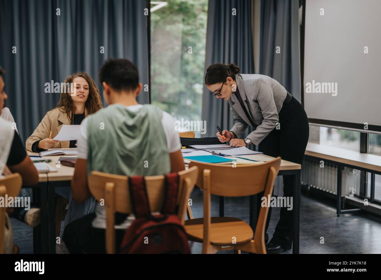 Teacher guiding students during interactive classroom learning session Stock Photo