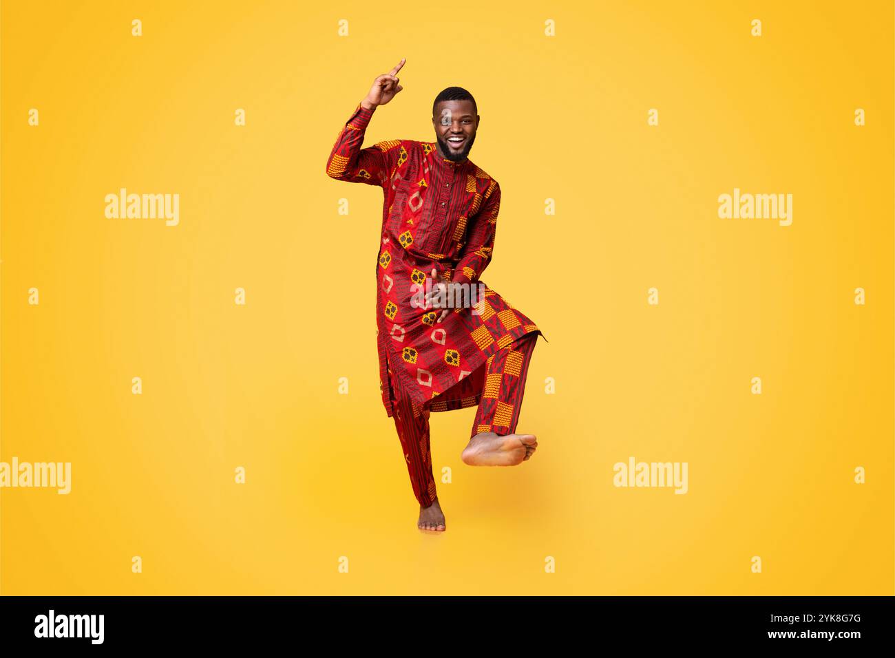 Cheery black guy having fun over yellow background Stock Photo