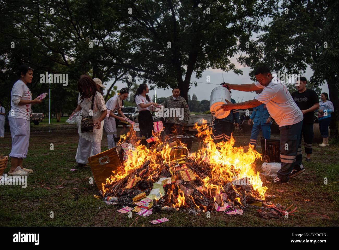 Volunteers burns a joss paper in a Chinese ritual during the cemetery ...